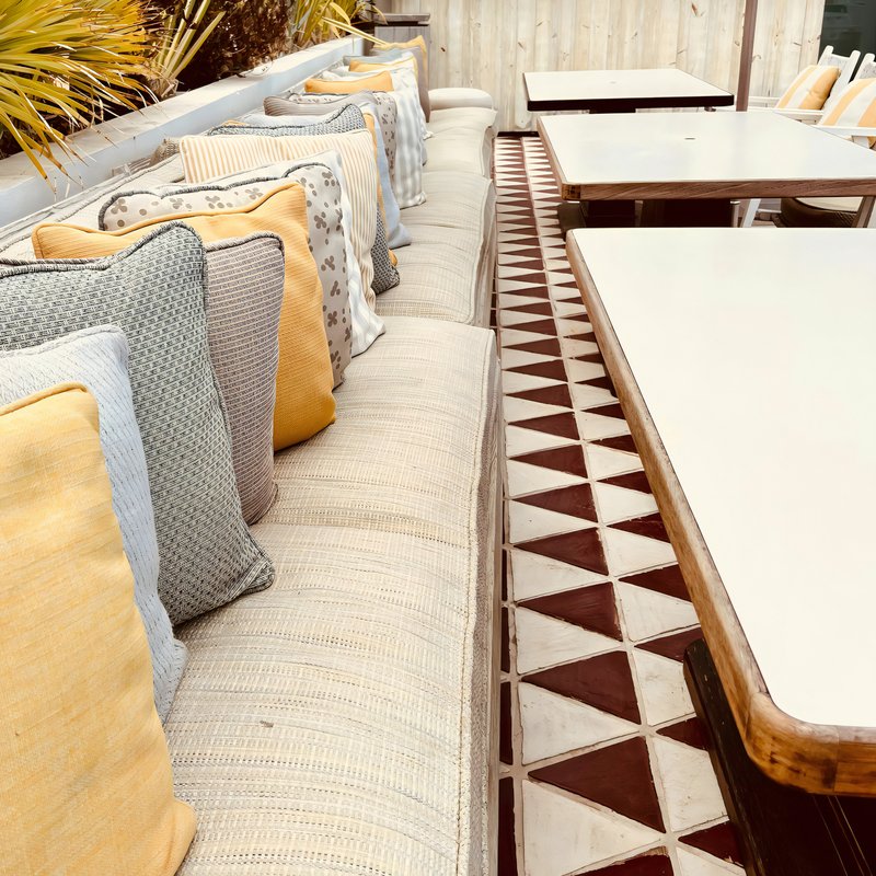 Coussins banquette extérieure avec des couleurs blanches, jaunes, grises et bleues