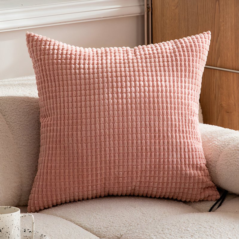 Coussin rose poudré avec des motifs géométriques