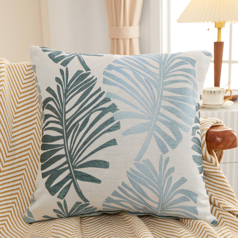 Coussin tropical avec des feuilles avec des nuances de bleu